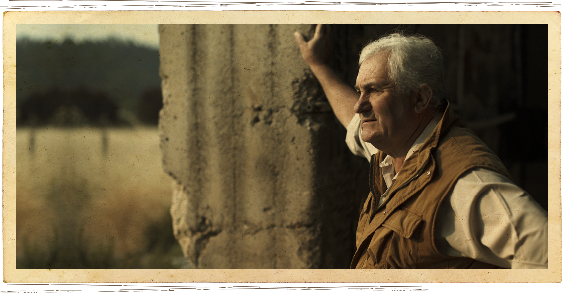 Pierre Seillan leaning against stone barn at Anakota estate